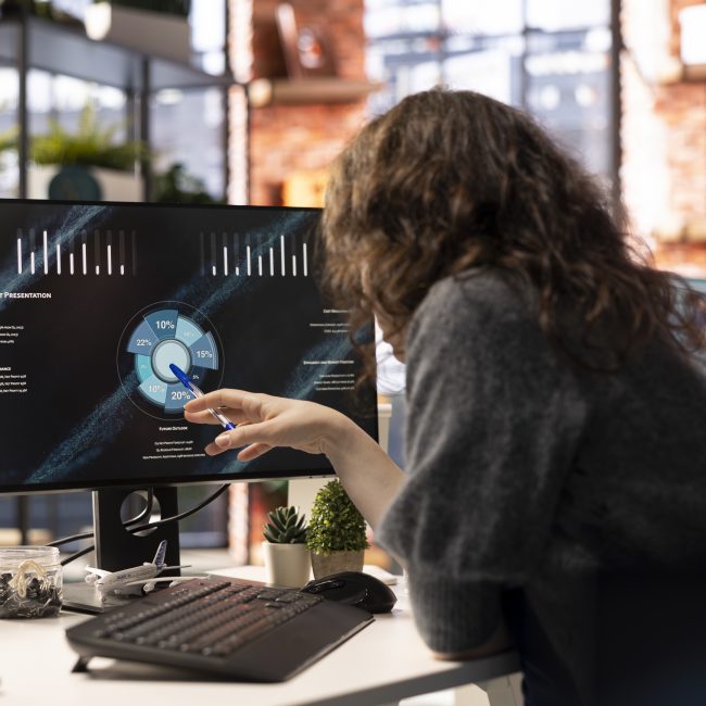 Analyst looking at presentation charts and dashboard to implement analytics