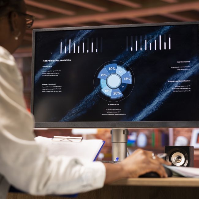 Woman watching business conference on computer screen, looking over statistics